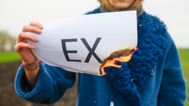 Mulher queimando um papel com a palavra 'ex'