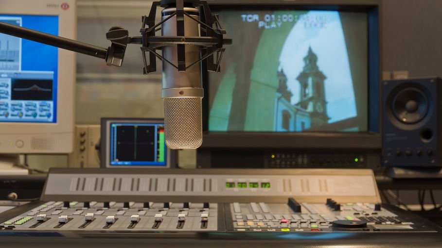 Foto de estúdio de gravação e dublagem com microfone, tv e botoões