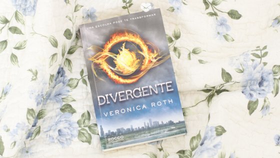 Jéssica Flores Livro Divergente em cima de uma cama