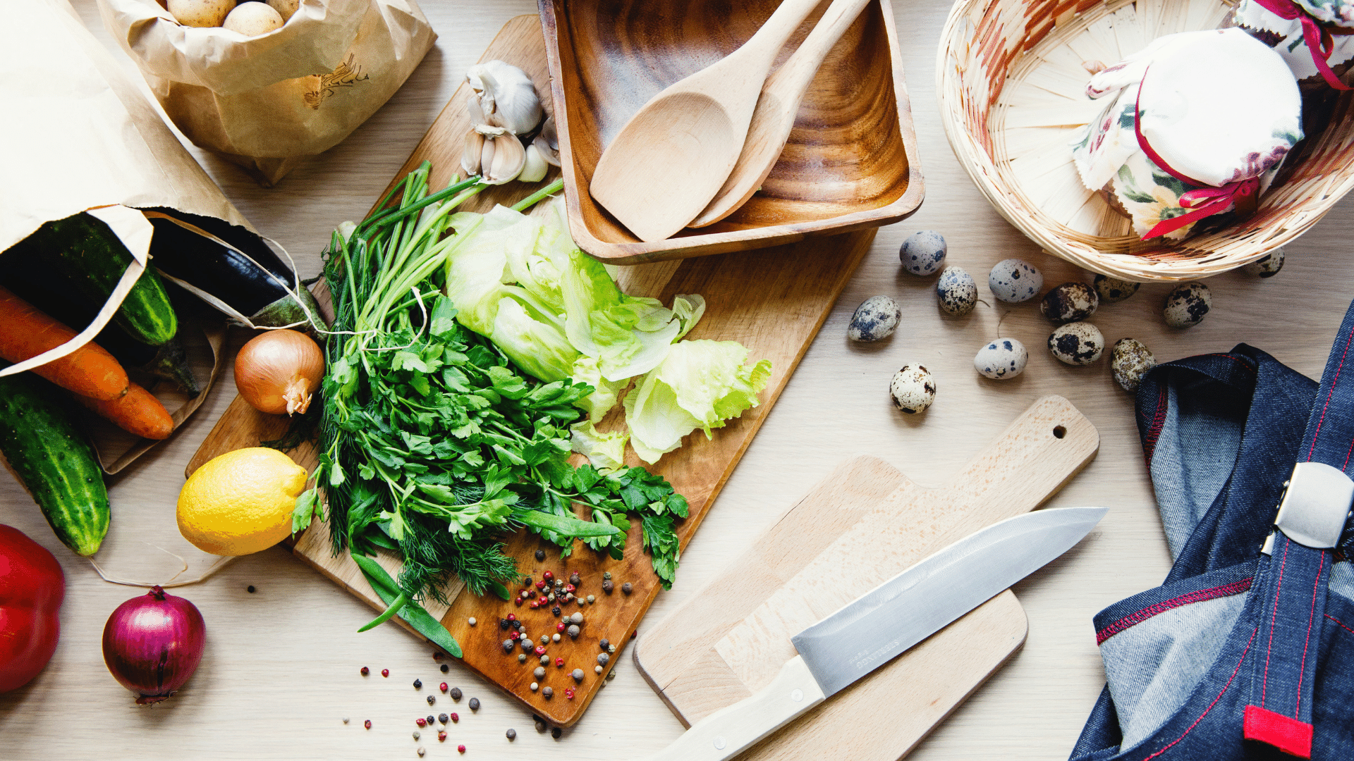 Foto de uma mesa cheia de legumes, verduras e aparatos de cozinha