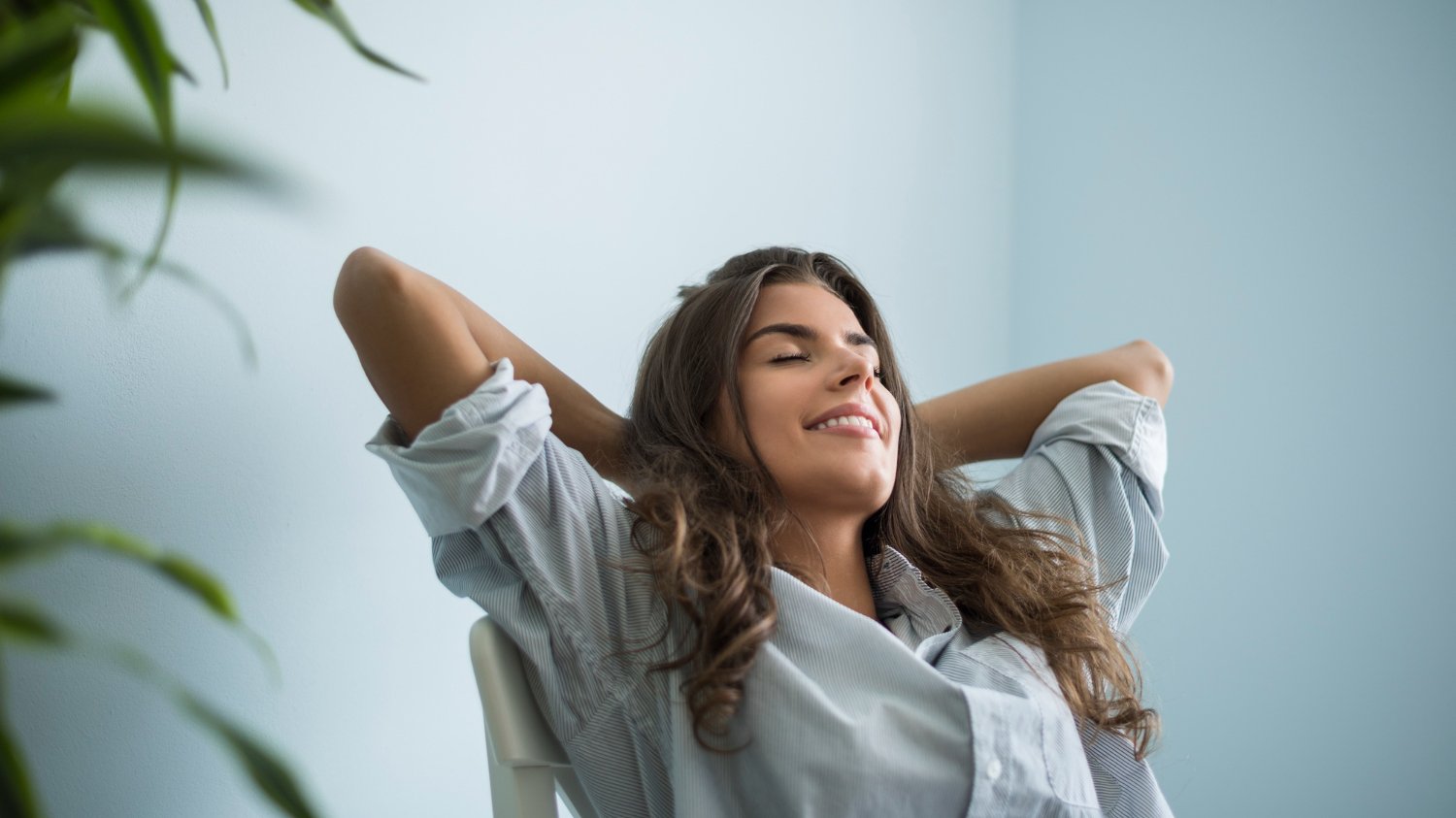 Mulher sentada em uma cadeira com expressão relaxada