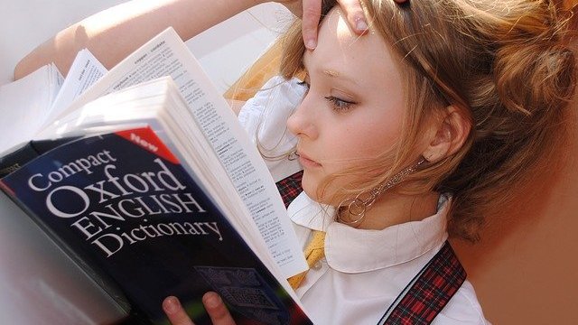 Menina lendo dicionário