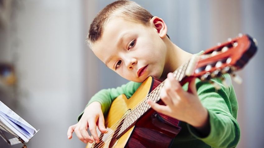 Criança tocando violão