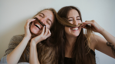 Duas amigas brincando uma com o cabelo da outra