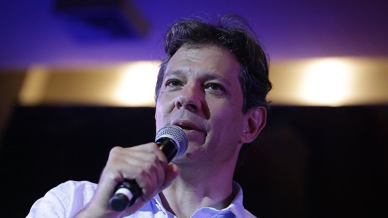 Fernando Haddad discursando com um microfone.