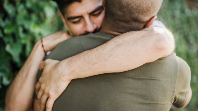 Dois homens se abraçando