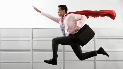 Homem com capa de super-herói e maleta executiva dando salto