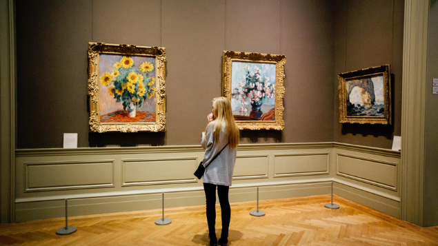 Mulher olhando quadros famosos no museu