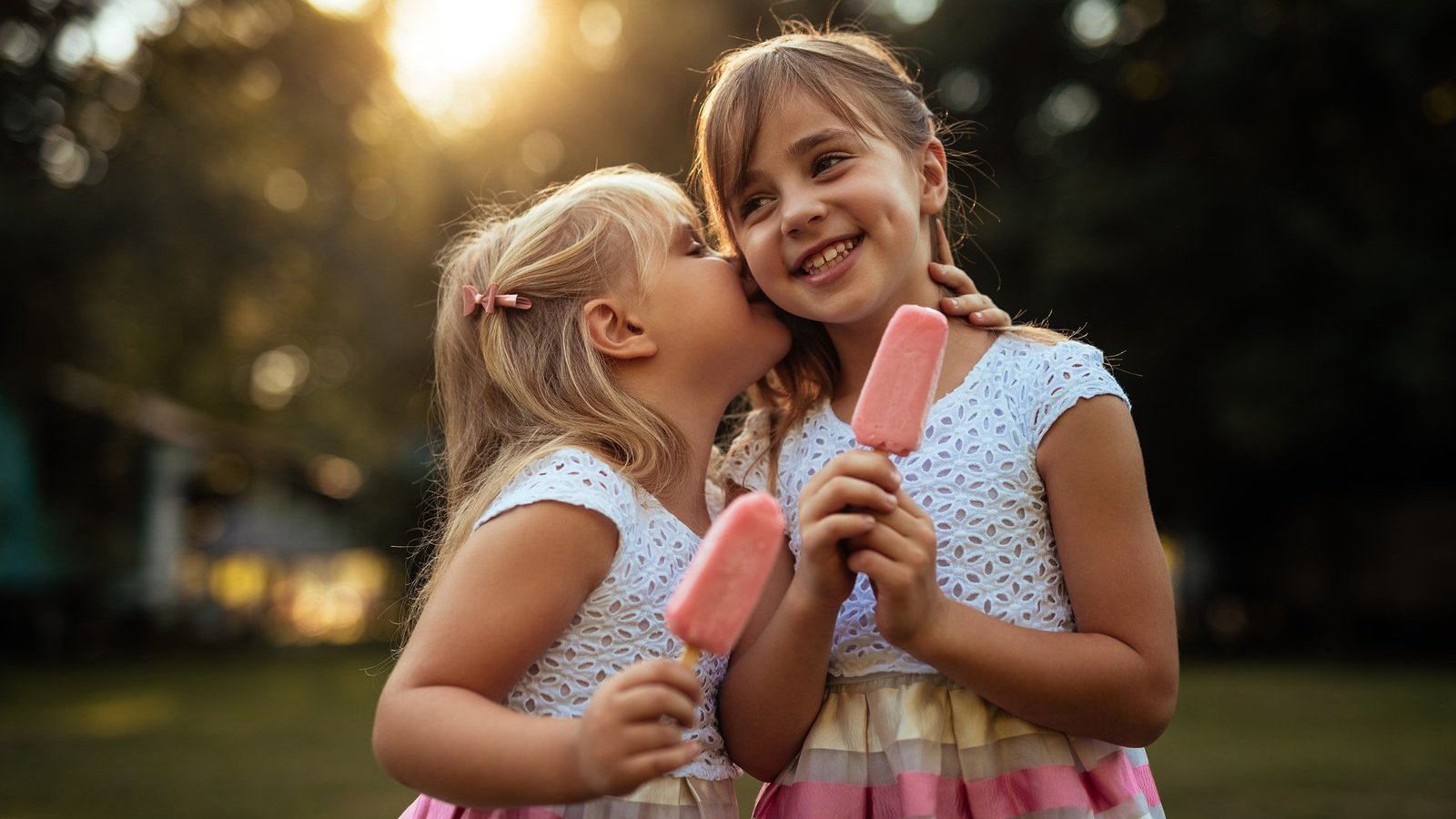 Duas meninas crianças rindo e tomando sorvete.