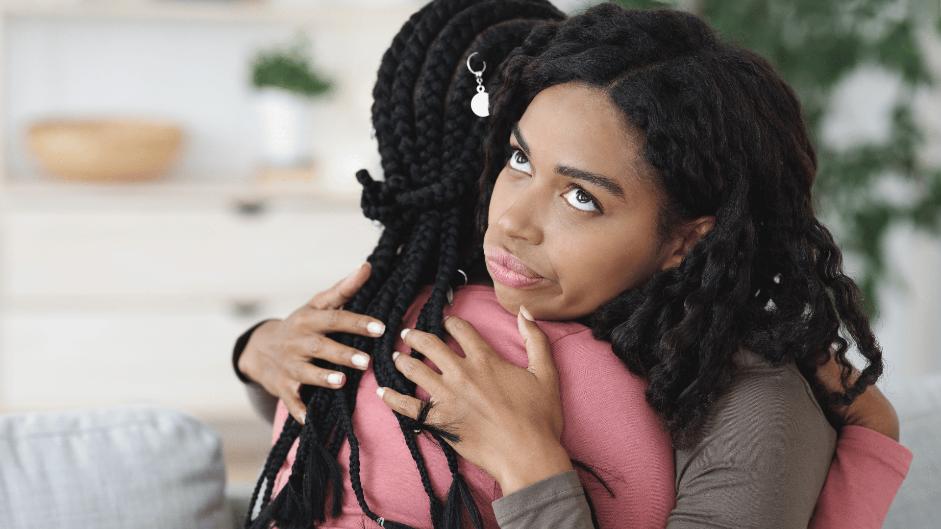 Mulher negra irritada abraçando sua amiga falsa.