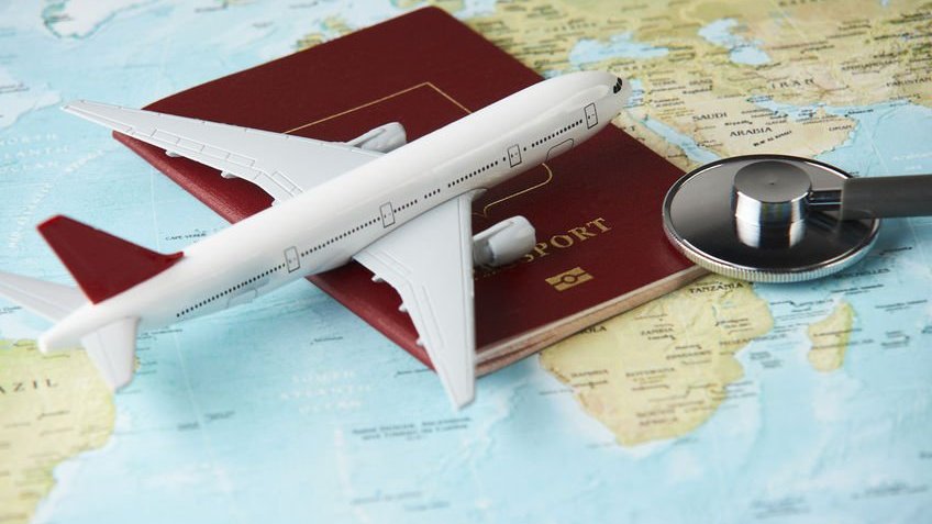Mapa Múndi com avião, passaporte e lupa em cima