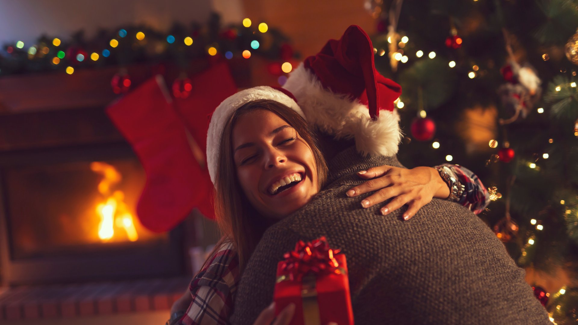 Casal trocando presentes no natal e se abraçando