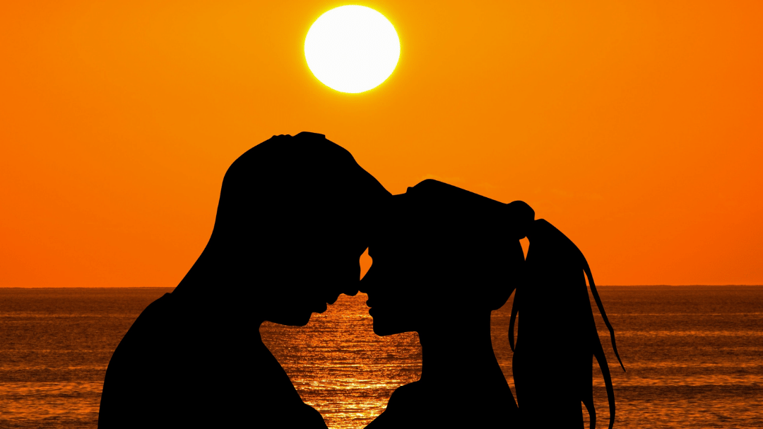 Casal se abraçando ao pôr do sol