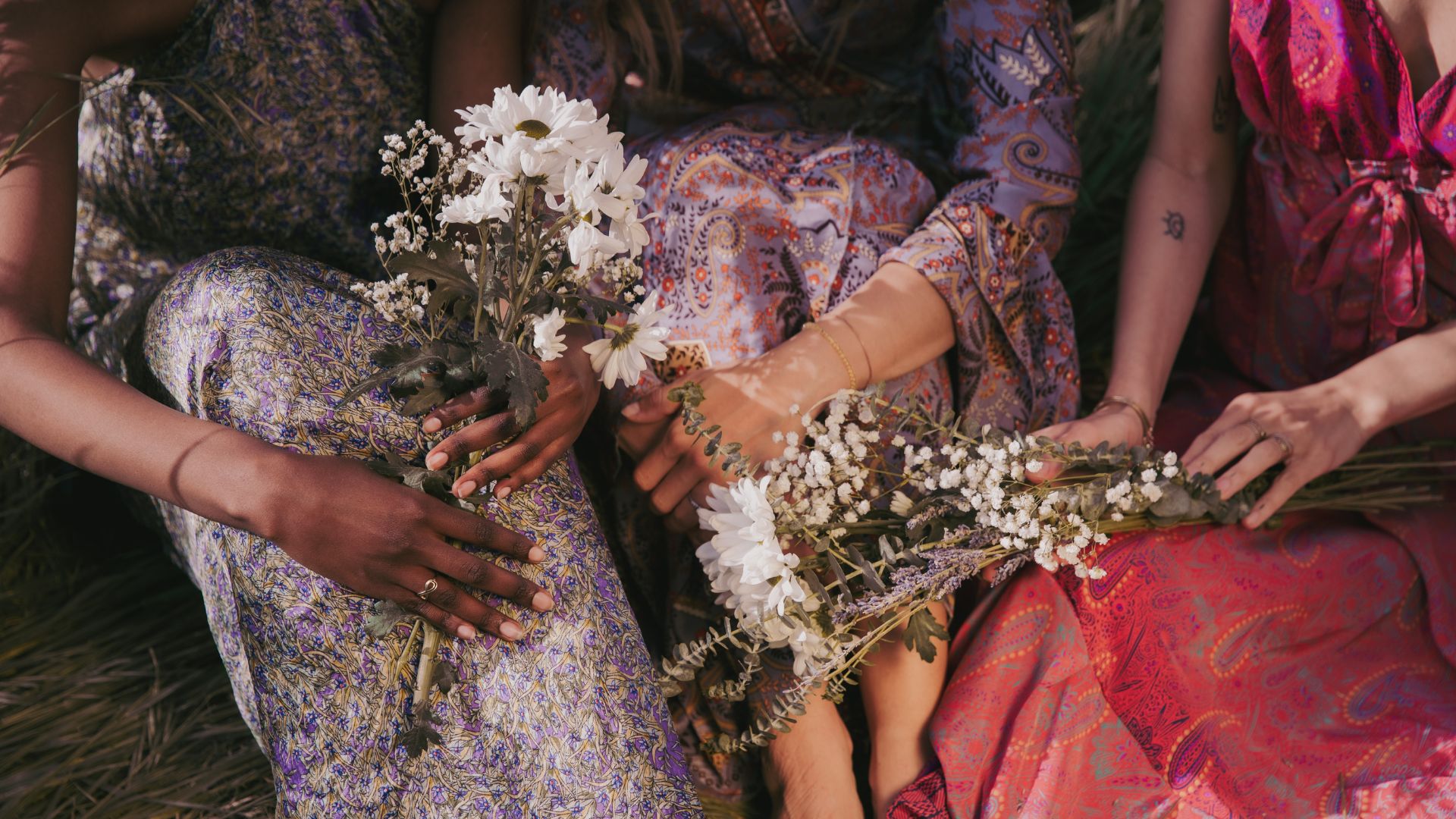 Três mulheres segurando flores