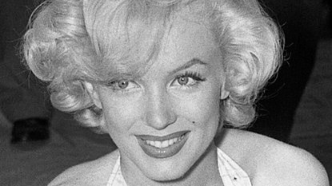 Foto em preto e branco de Marilyn Moroe sorrindo.