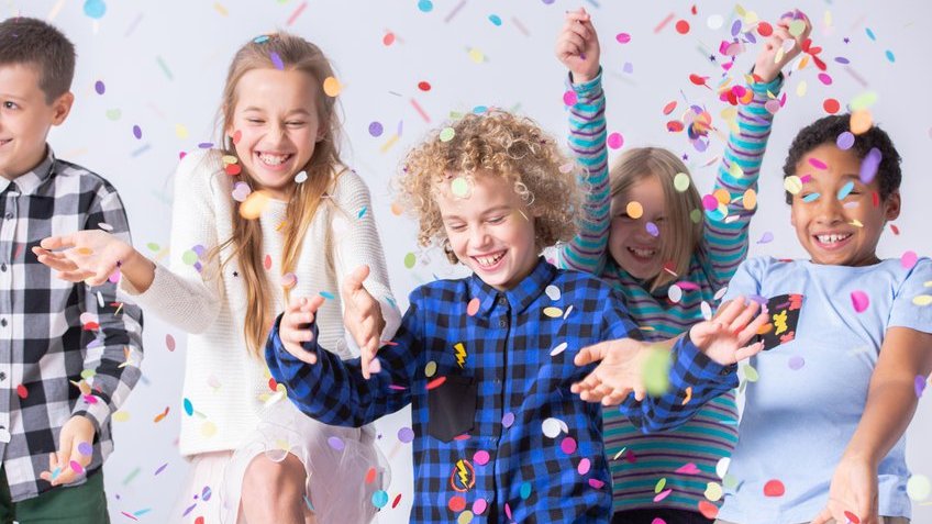Crianças felizes com confetes coloridos.