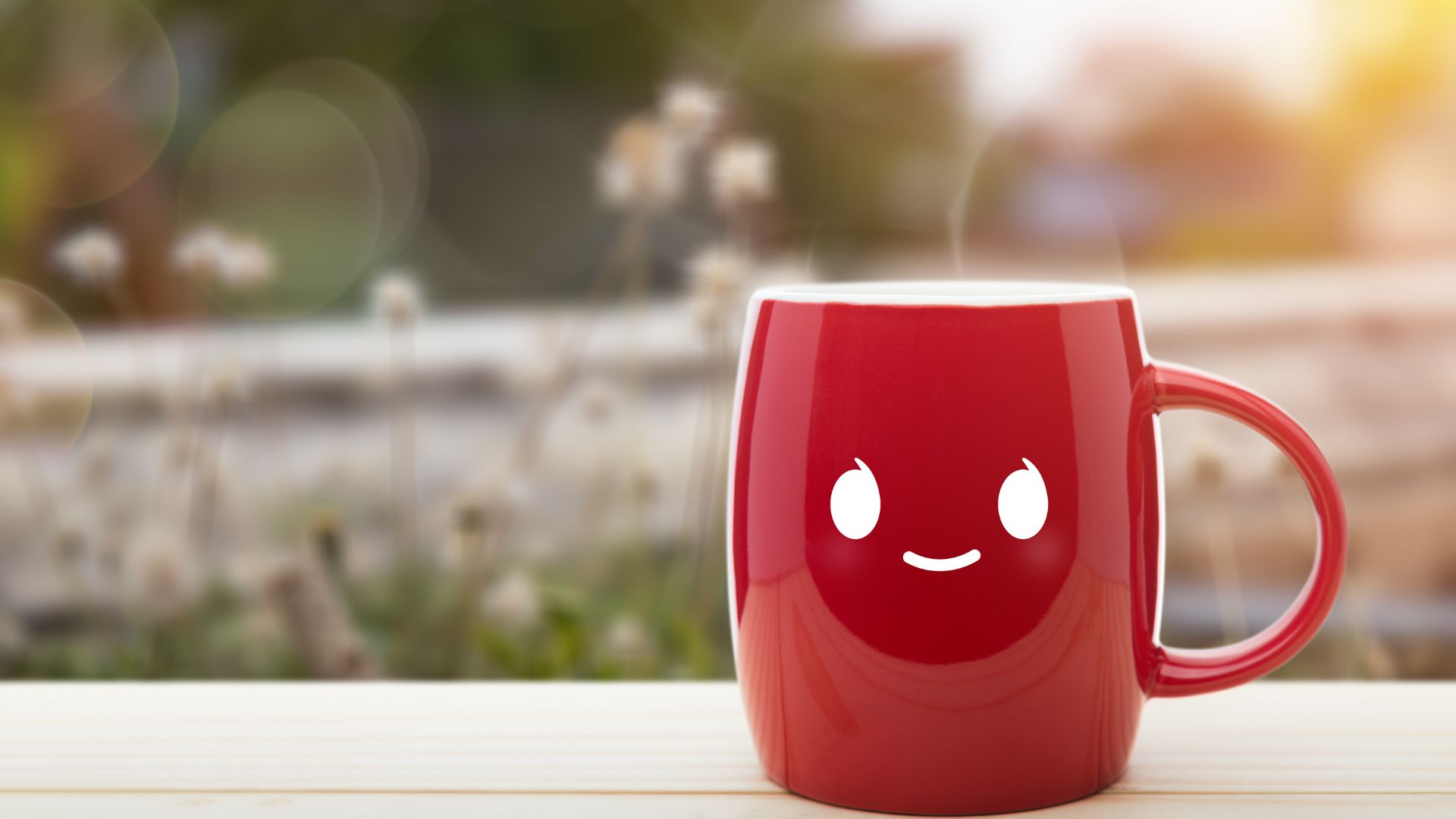 Imagem de uma caneca vermelha de café co um rostinho desenhado