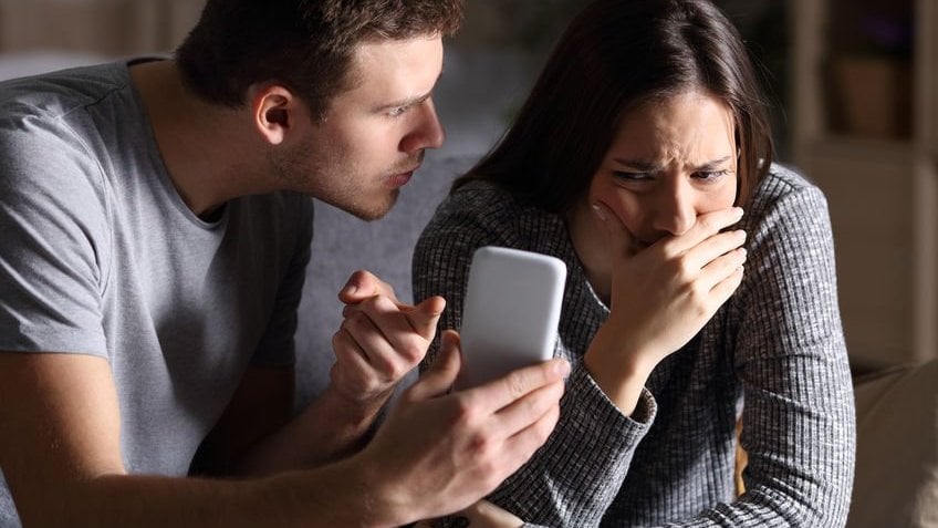 Homem brigando com mulher por ciúmes de coisas no celular