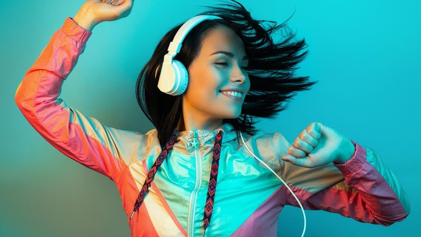 123rf/sklyareek Mulher dançando enquanto usa fone de ouvido.
