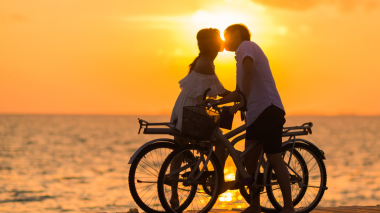 Casal de beijando ao pôr do sol na praia