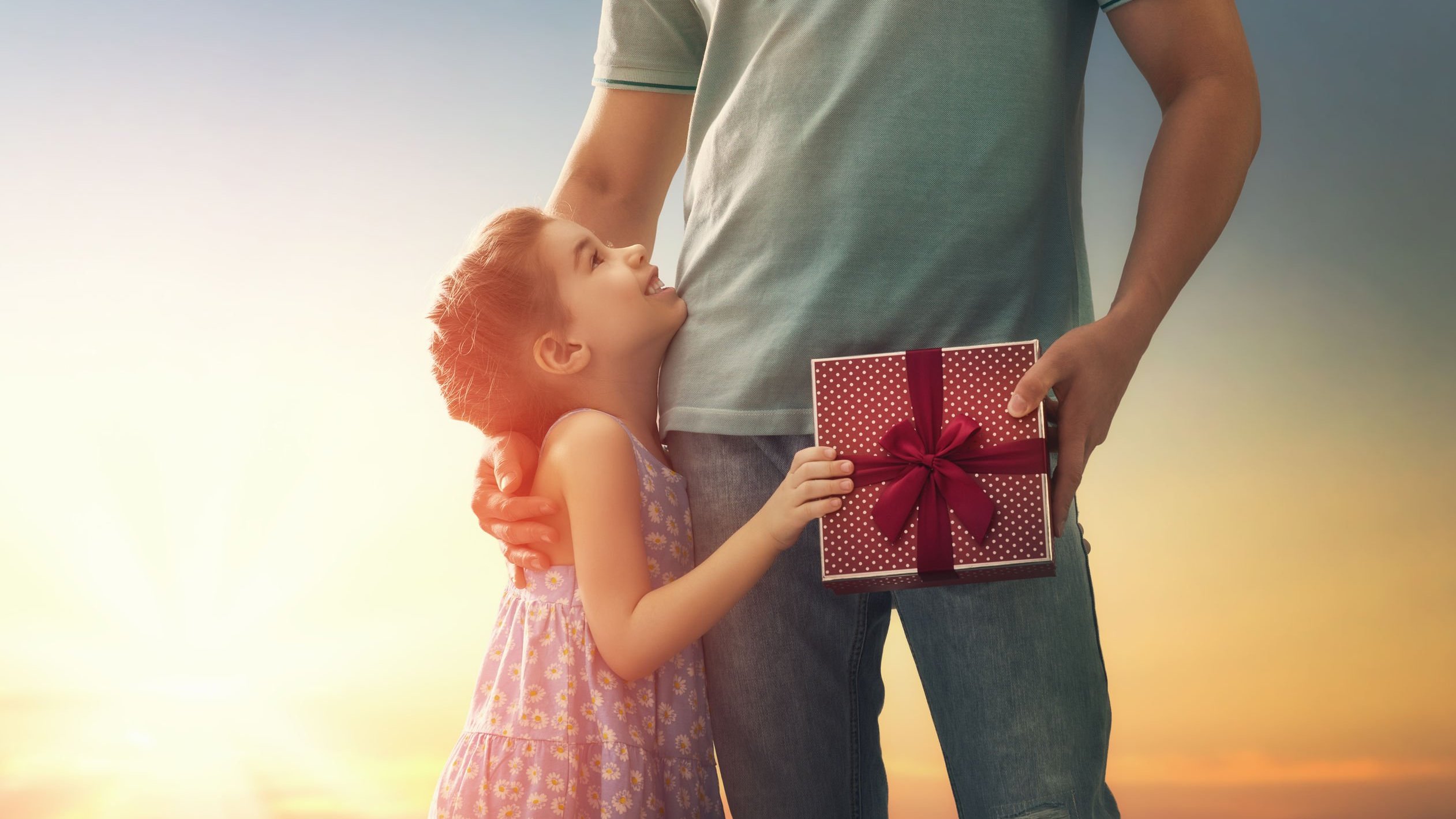 Criança menina entregando um presente para o seu pai.