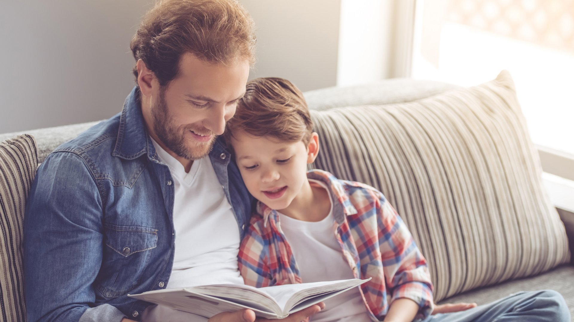 Pai e filho pequeno lendo um livro juntos