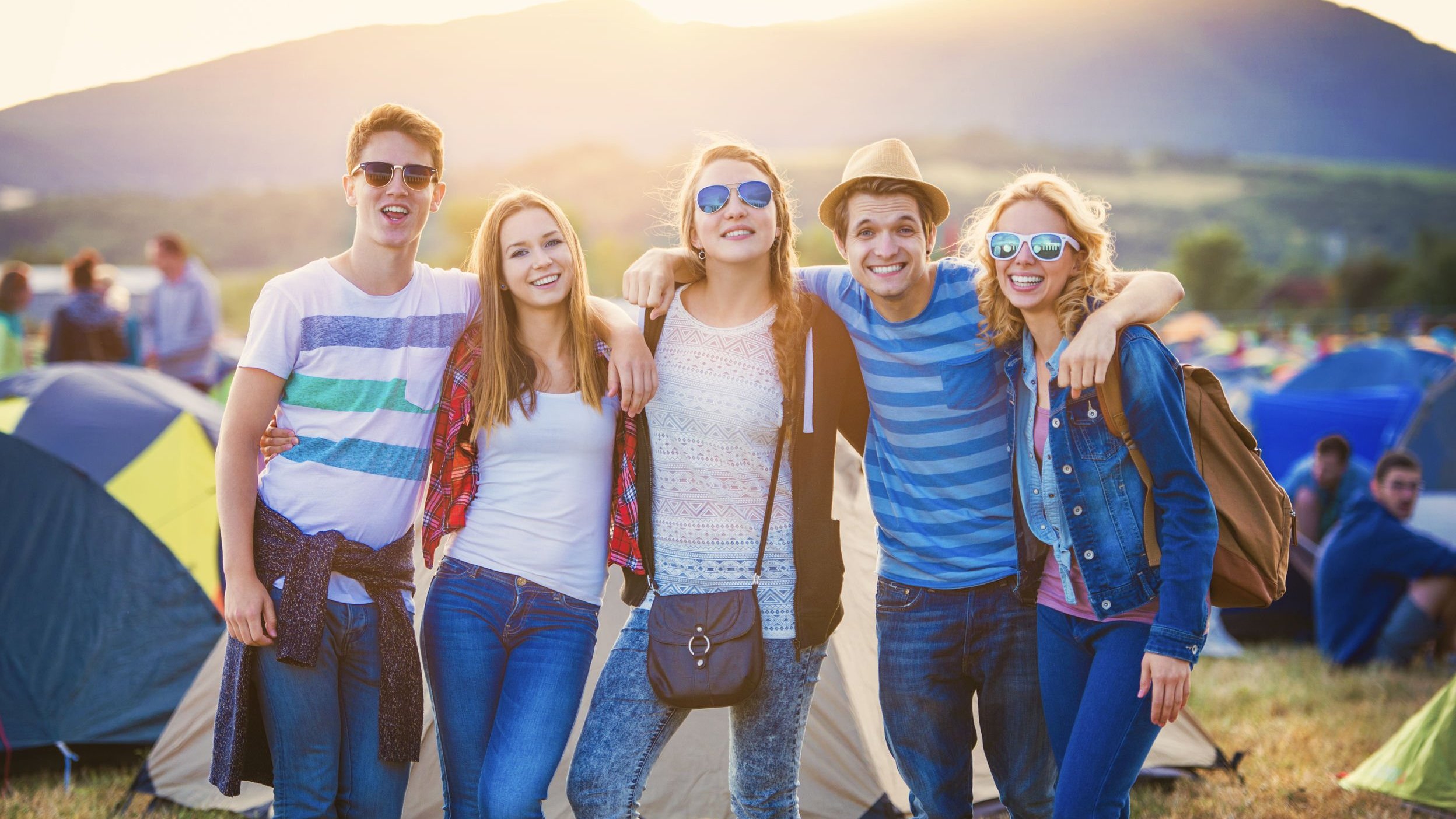 Grupo de amigos abraçados em acampamento