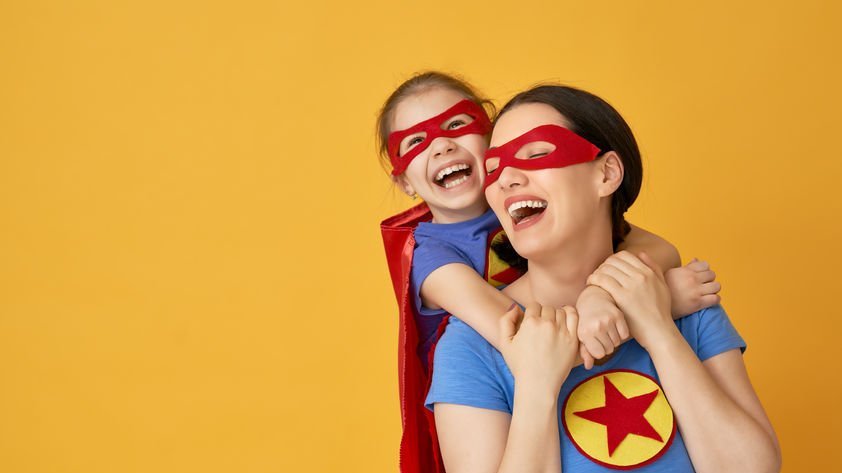 Mãe e filho com fantasias de super-heróis brincando juntos