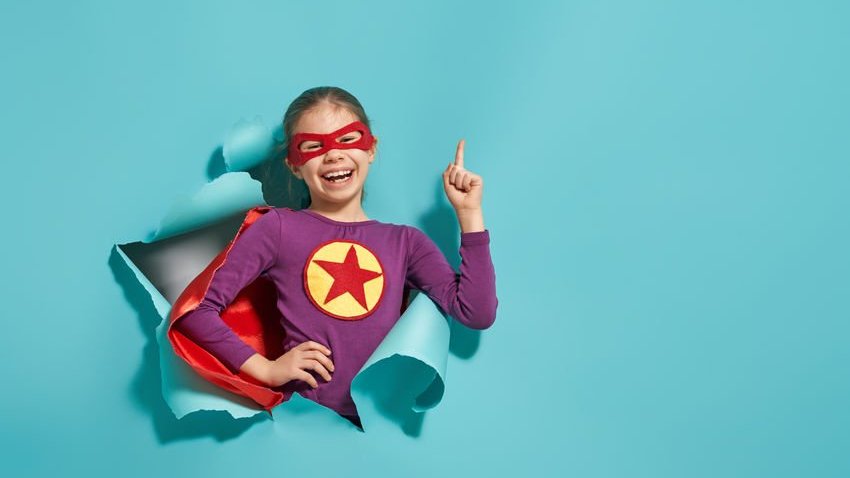 Criança sorrindo com fantasia de super-herói