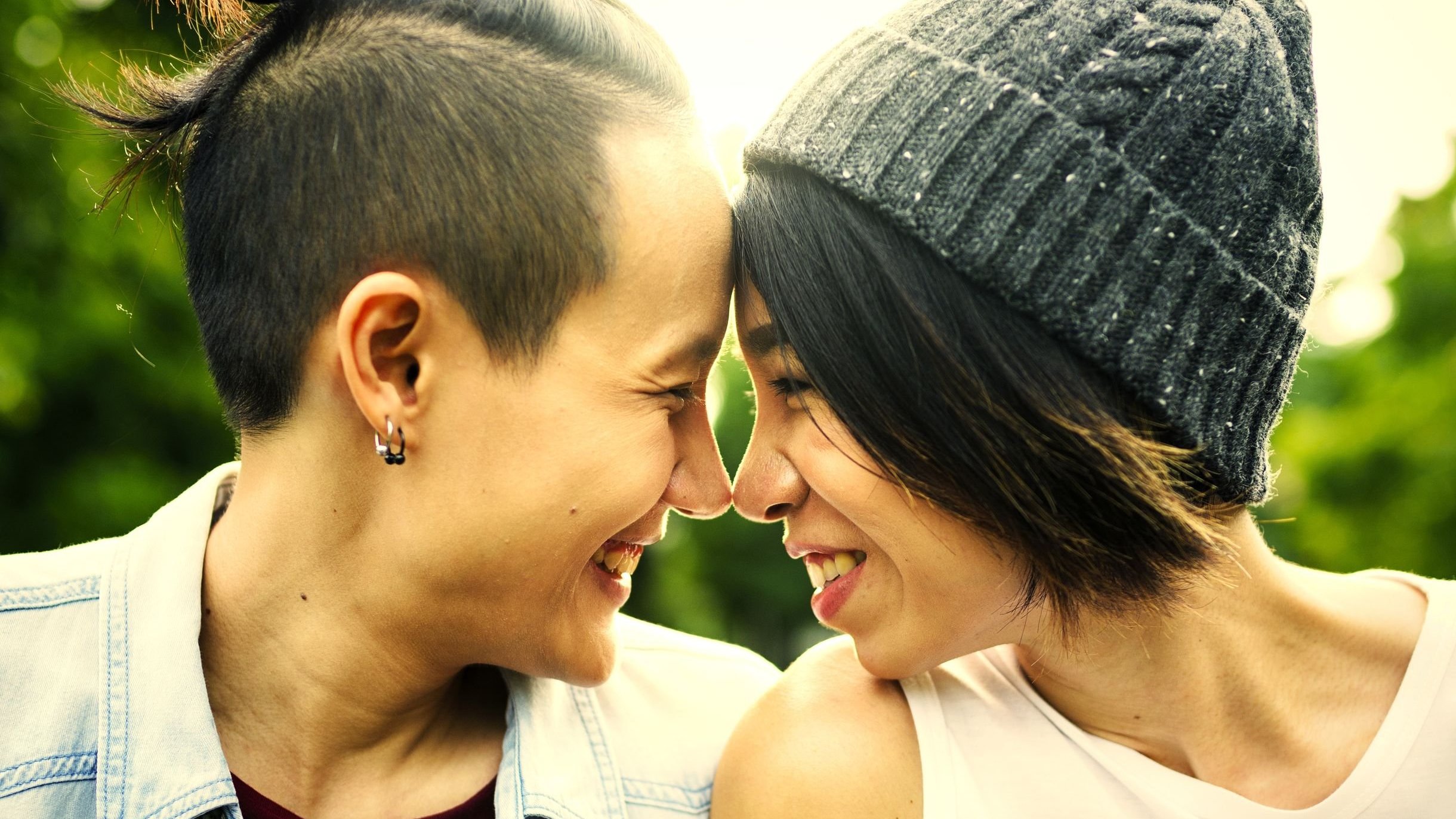 123rf - rawpixel Duas mulheres se olhando e sorrido, com seus narizes se encostando.