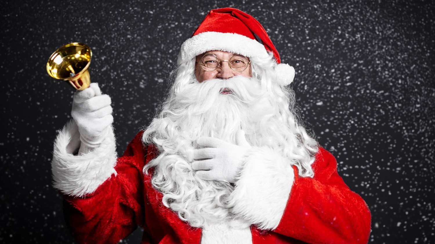 Papai Noel segurando um sino e sorrindo