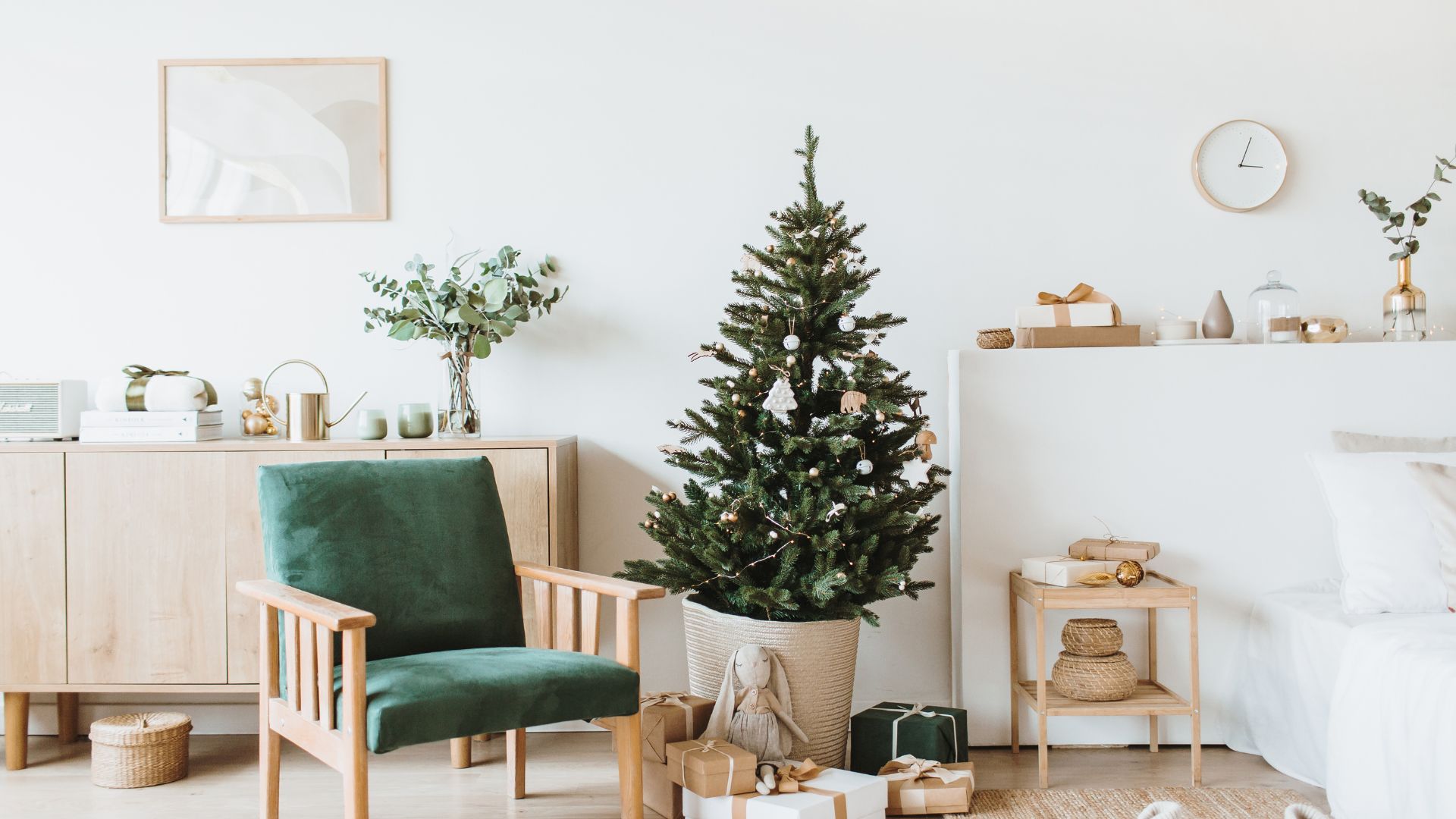 Imagem de fundo branco com vários elementos decorativos de natal, em tons de verde e palha, como: árvore, presentes, cadeira e arranjos florais.