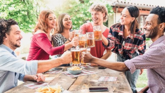 charmedlightph / Shutterstock Grupo de amigos brindando com copos de chop.