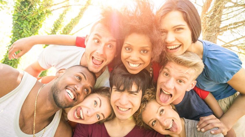 Amigos tirando selfie ao ar livre com iluminação de fundo