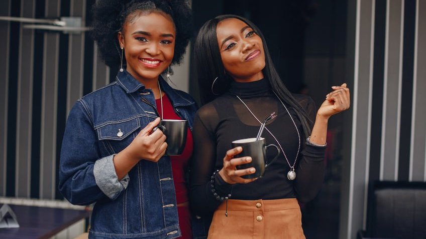 Meninas felizes segurando canecas em casa