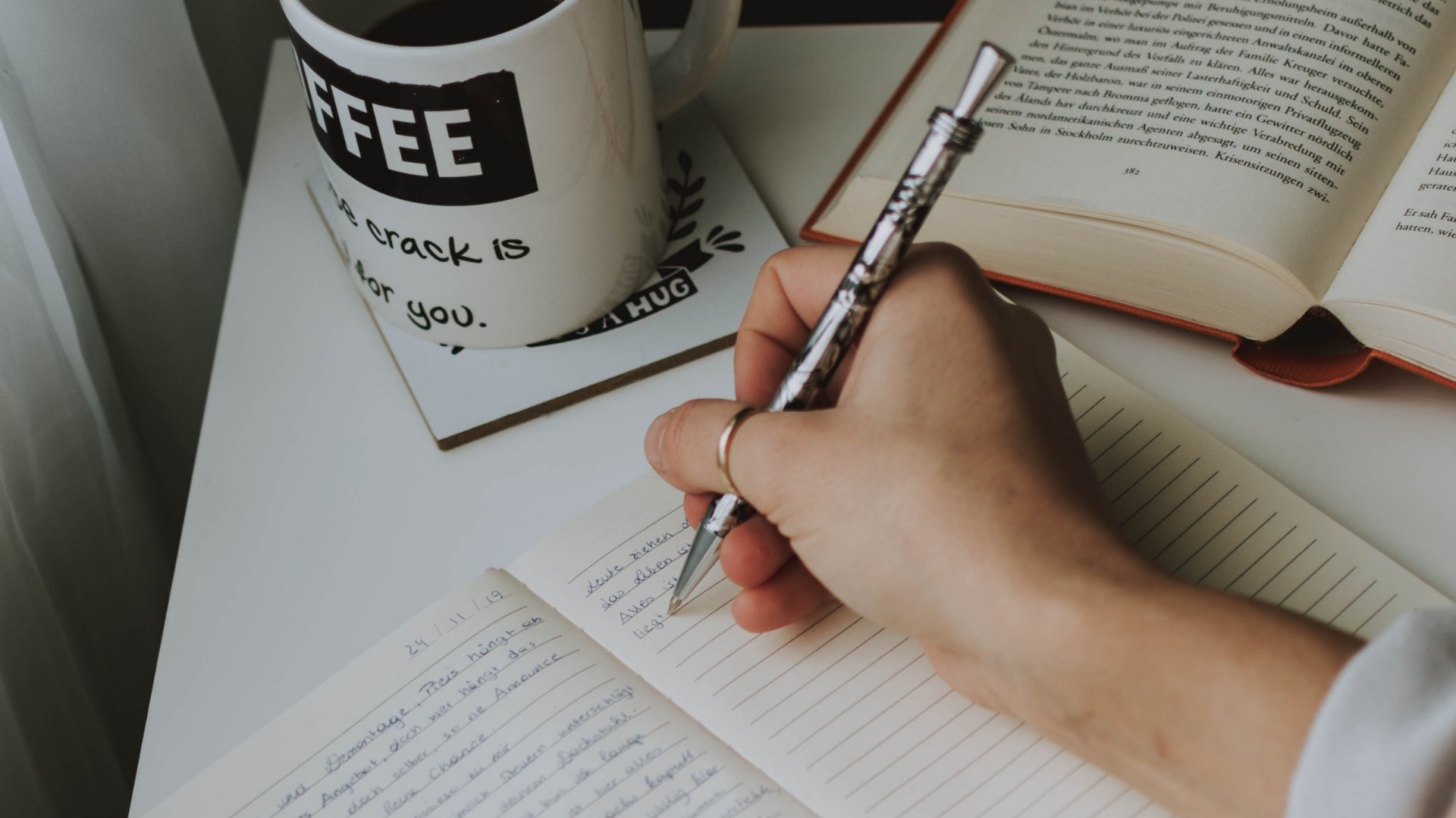 Fotografierende / Pexels / Canva Mão escrevendo no caderno promessas de ano novo