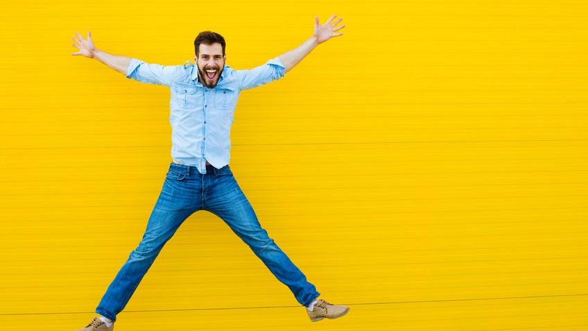 Homem saltando feliz em fundo amarelo