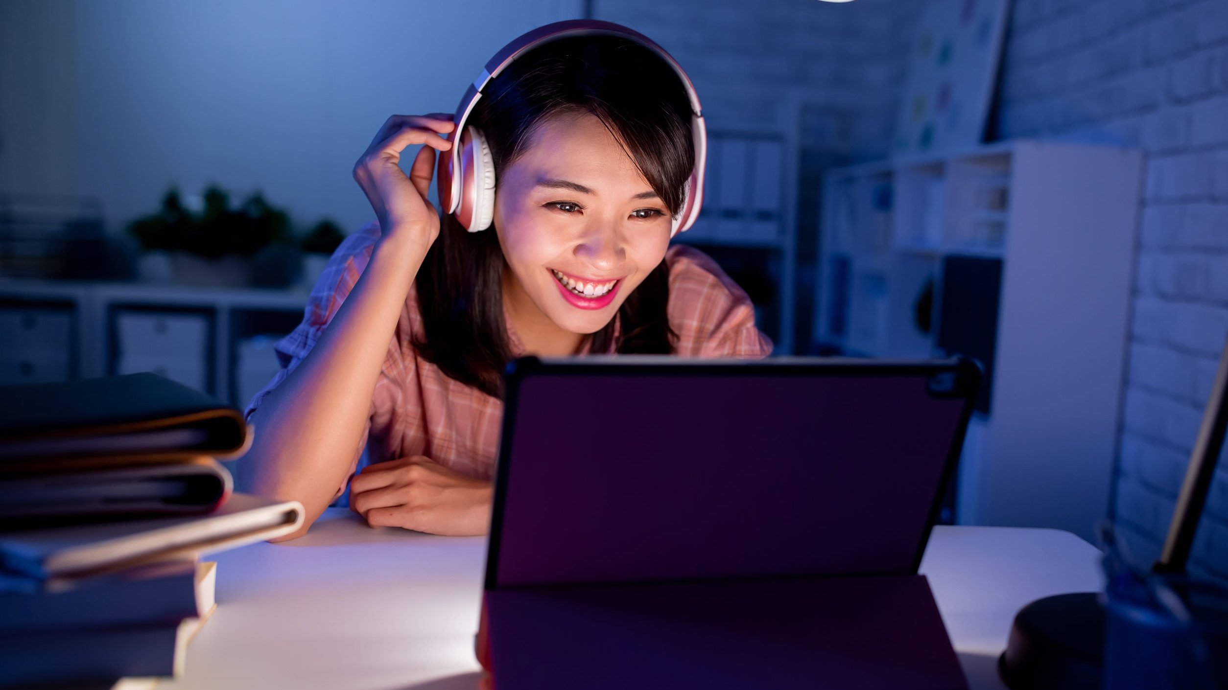 Mulher de fones de ouvido assistindo algo em seu computador