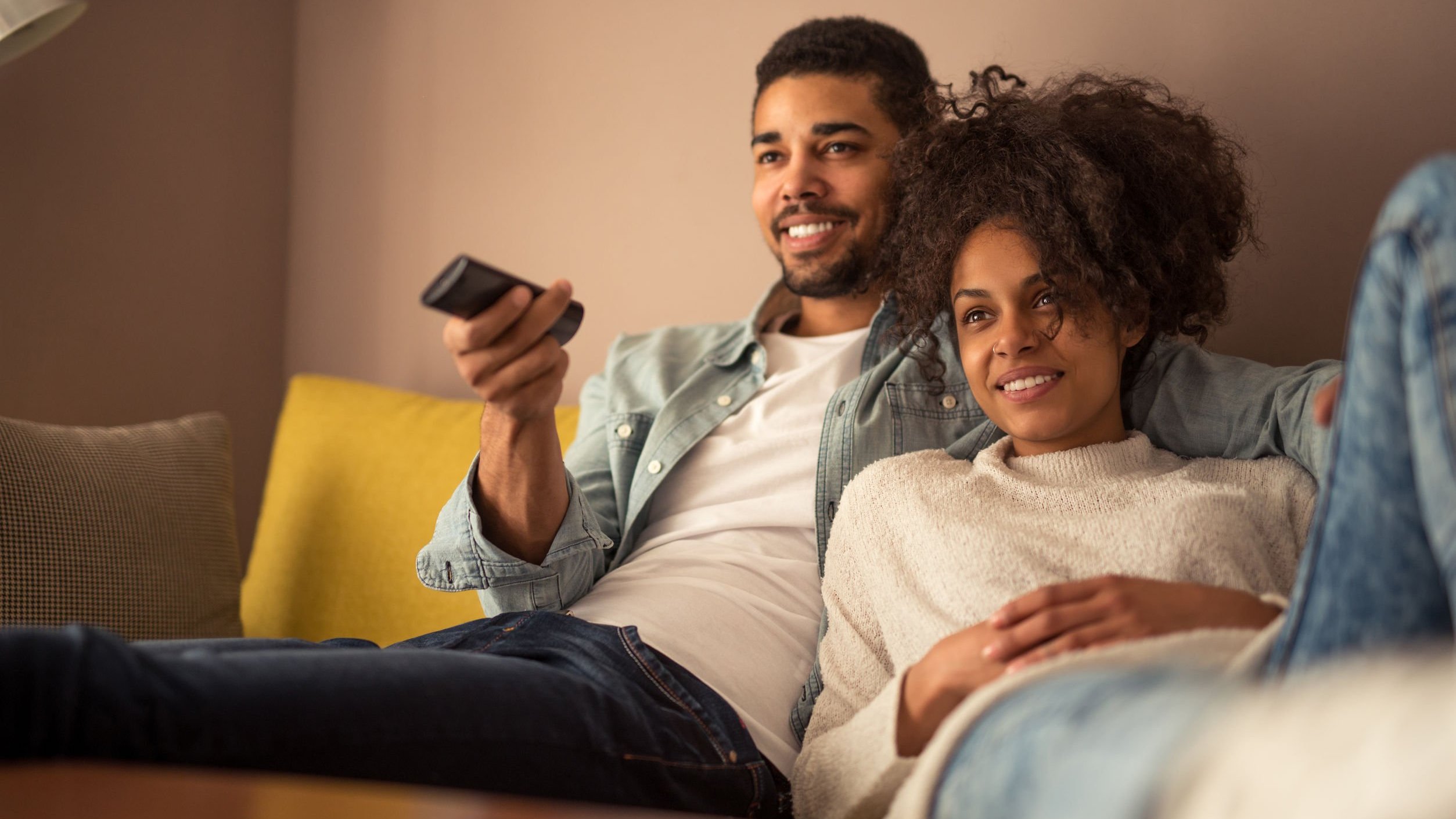 123rf Casal sentado no sofá assistindo televisão