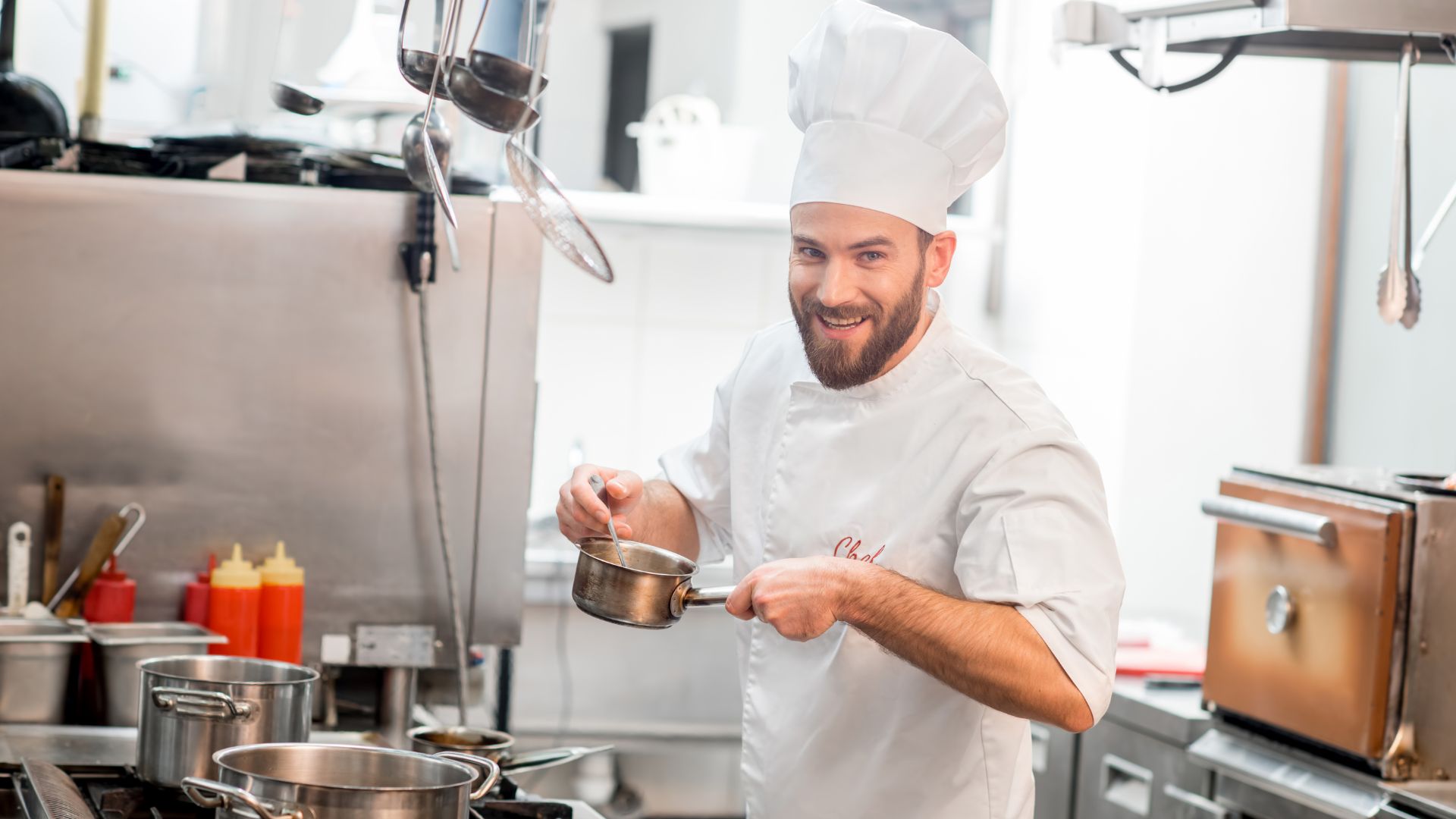 Imagem de um chef de cozinha fazendo cozinhando e sorrindo