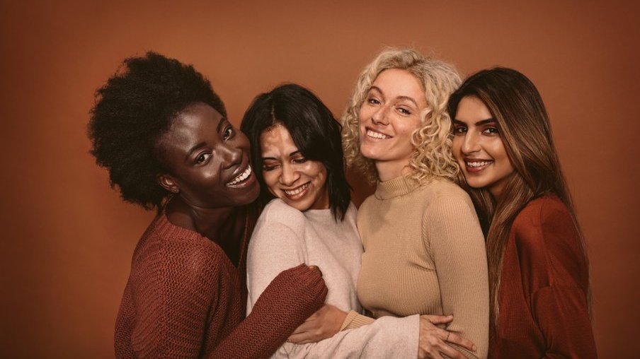 Mulheres sorrindo e se abraçando.