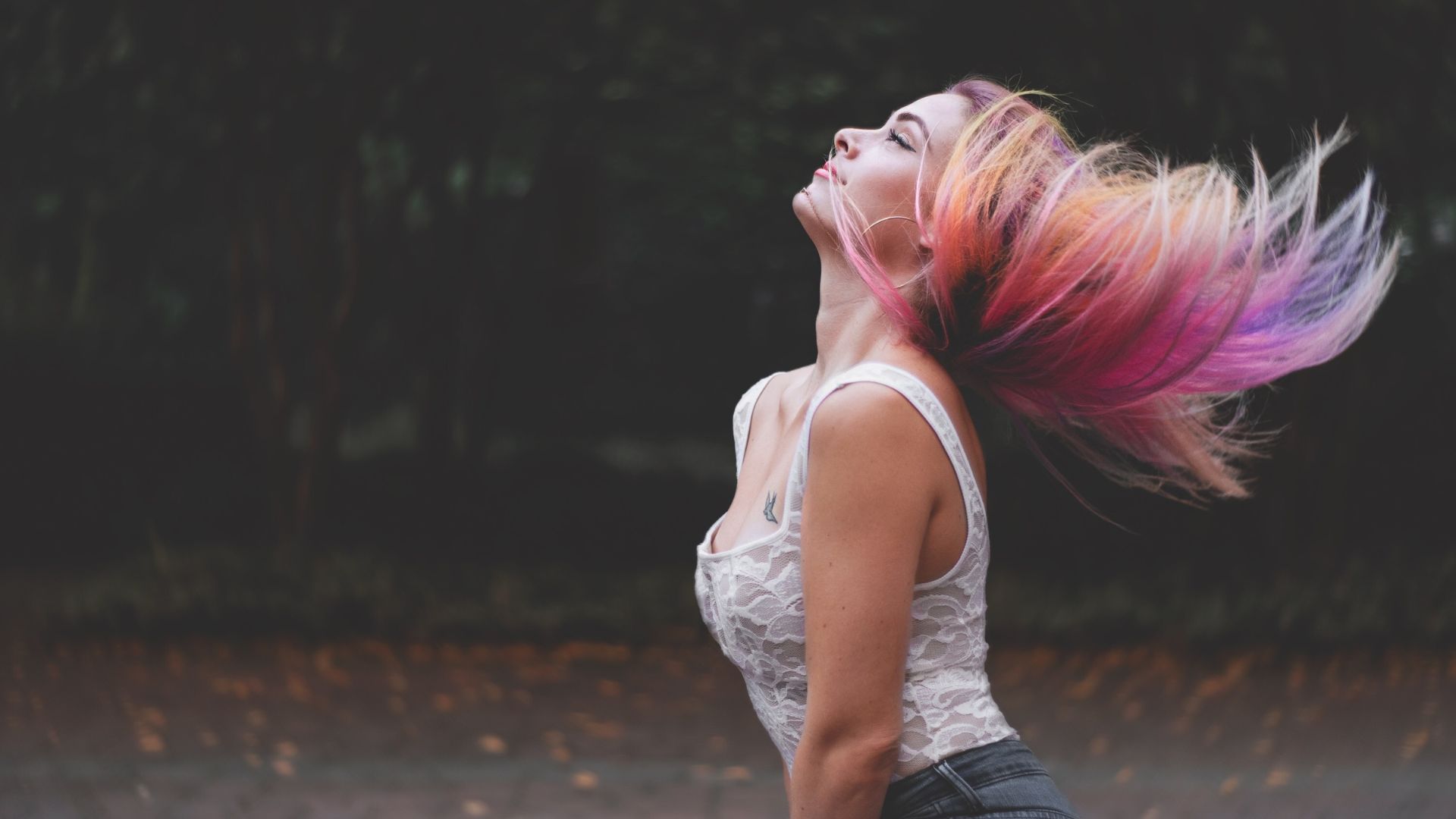 Pexels de pixabay Imagem de uma jovem usando uma regata branca de renda e calça jeans. Possui cabelos longos e coloridos.