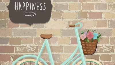 Placa escrito happiness em cima de uma bicicleta.