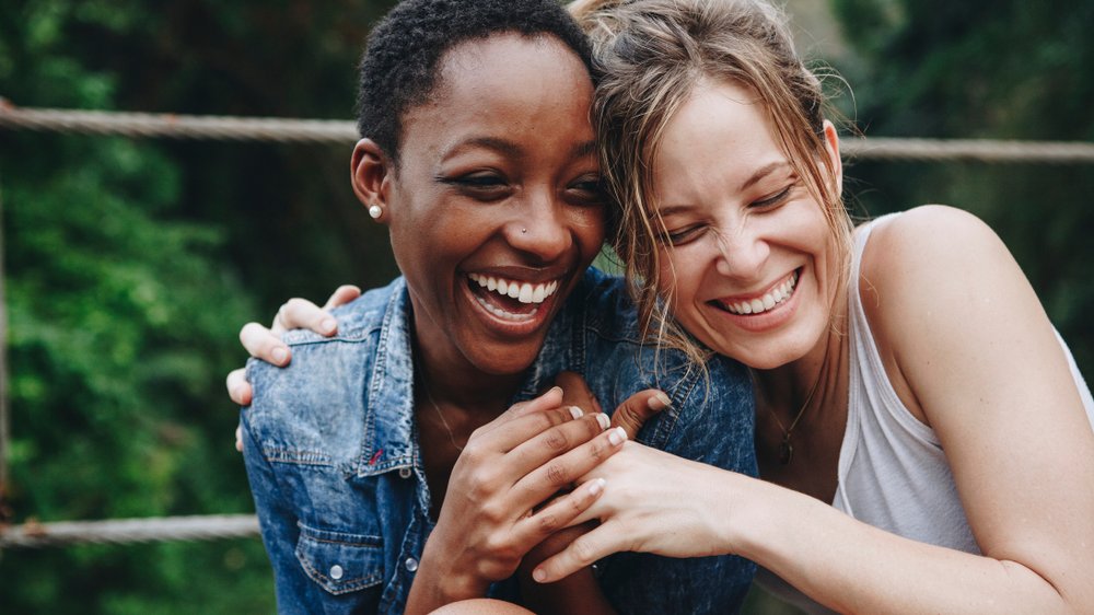 Duas mulheres se abraçando e sorrindo