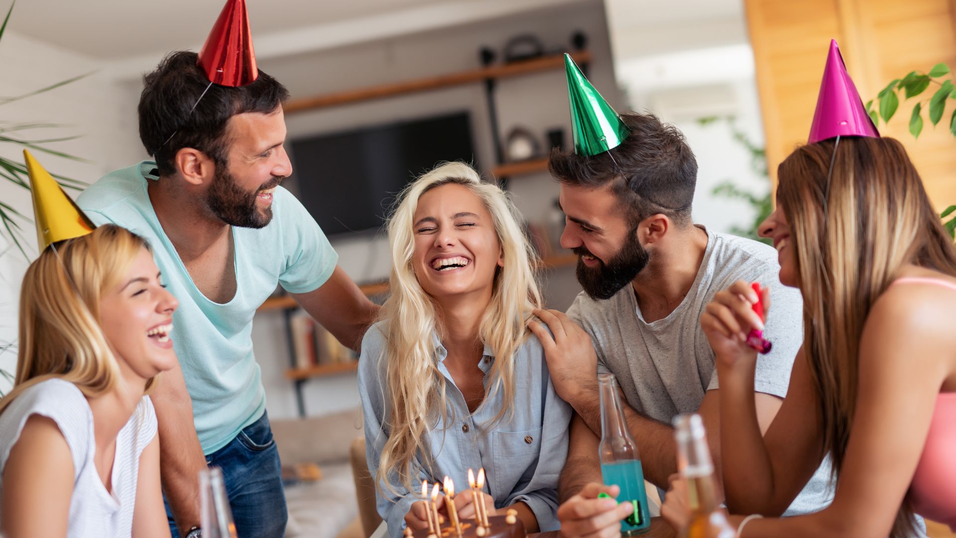 Imagem de 5 pessoas celebrando o aniversário da esposa de um dos homens presentes na foto.