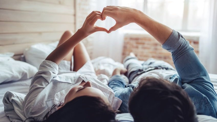 Casal deitado formando coração