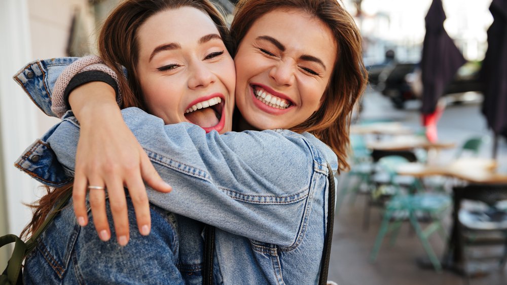 Amigas se abraçando e sorrindo para foto