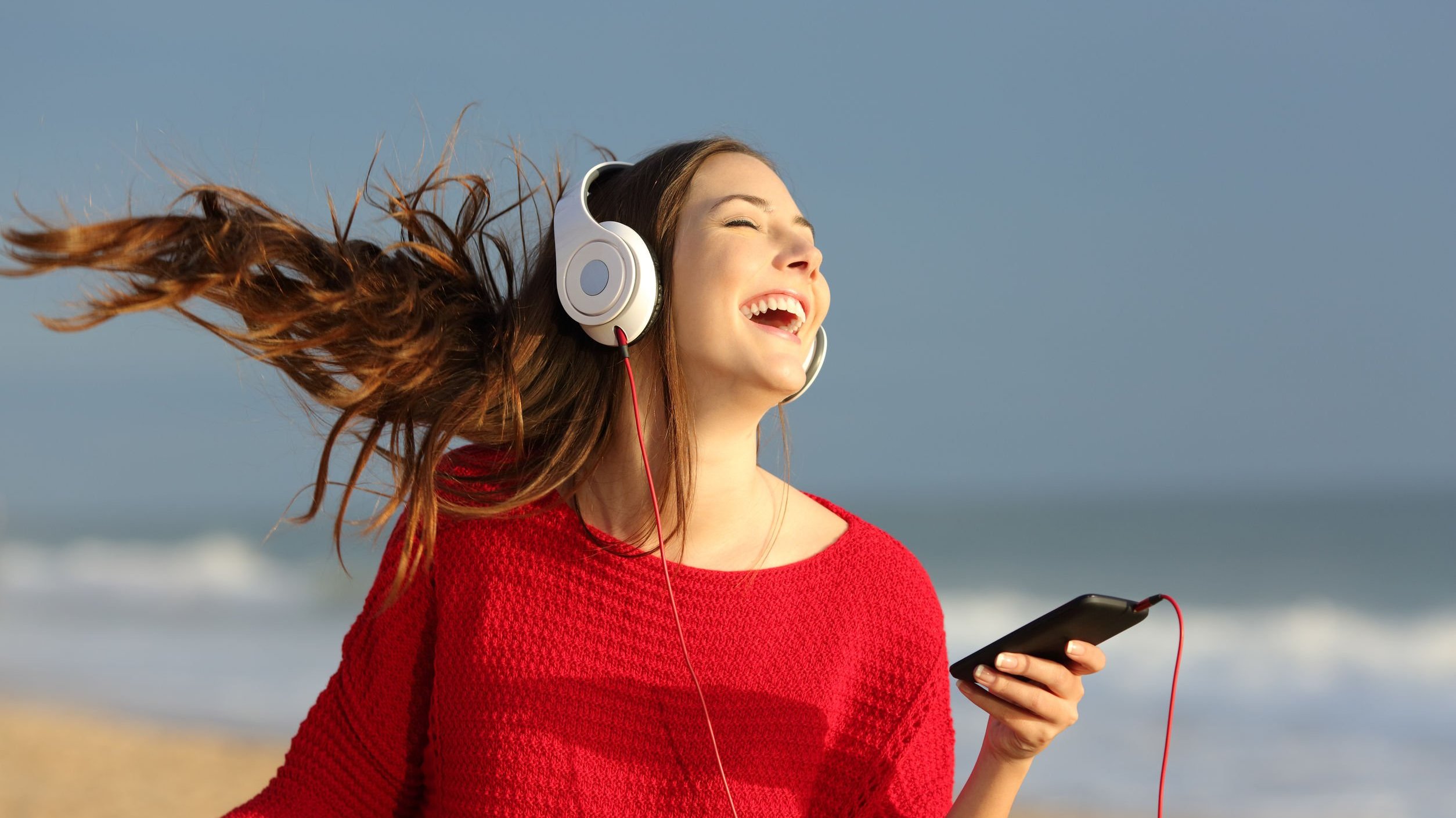 Mulher sorridente ouvindo música com fones de ouvido