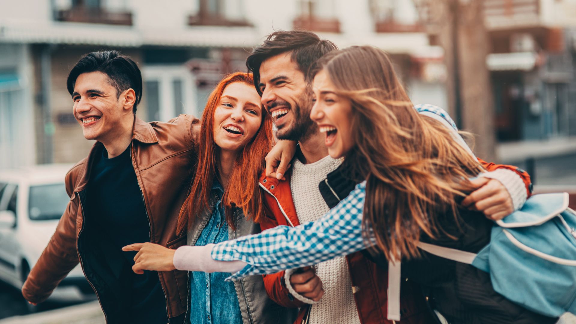 Mensagens Com Amor / Canva / filadendron de Getty Images Signature Imagem de quatro amigos, dois homens e duas mulheres, andando abraçados e dando risada.