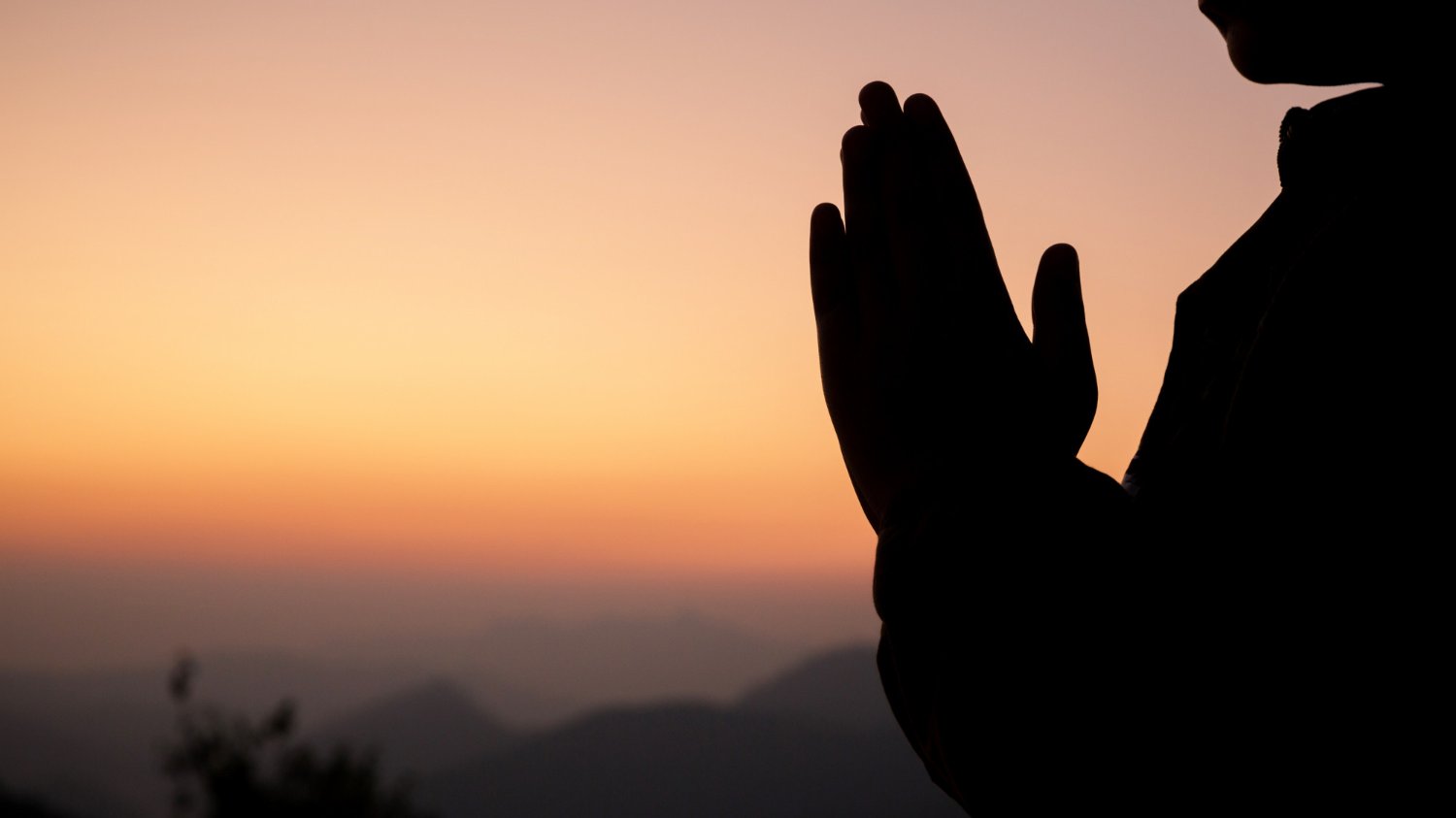 Silhueta de mãos em pose de oração